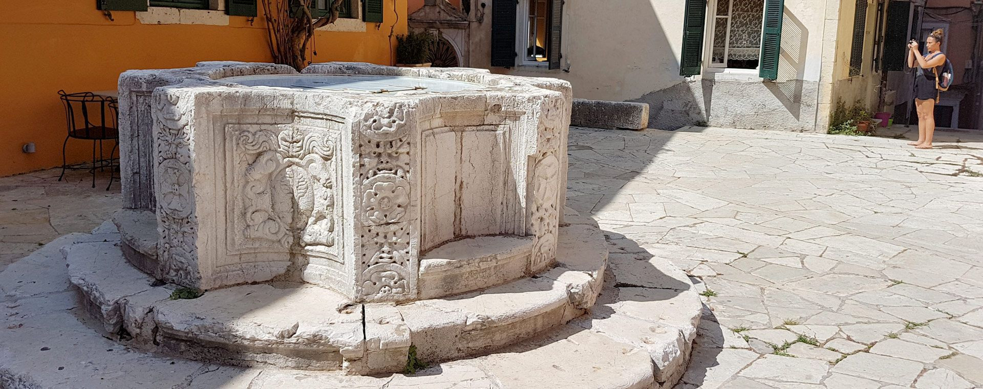 Puits vénitien sculpté sur une placette pavée - vieille ville de Corfou - Grèce