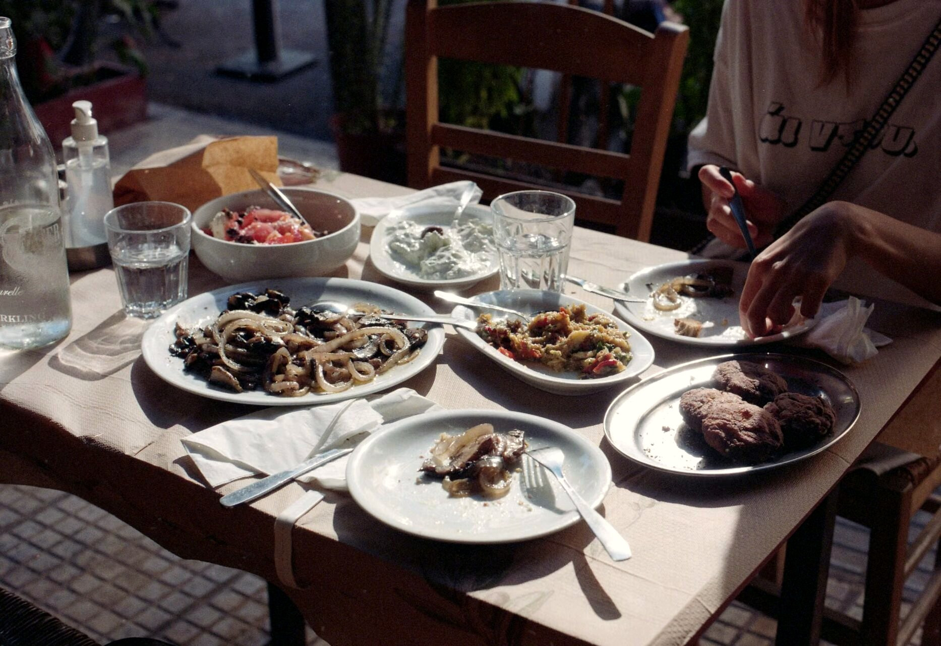 Tavola di taverna greca all'aperto, piatti da condividere - Grecia