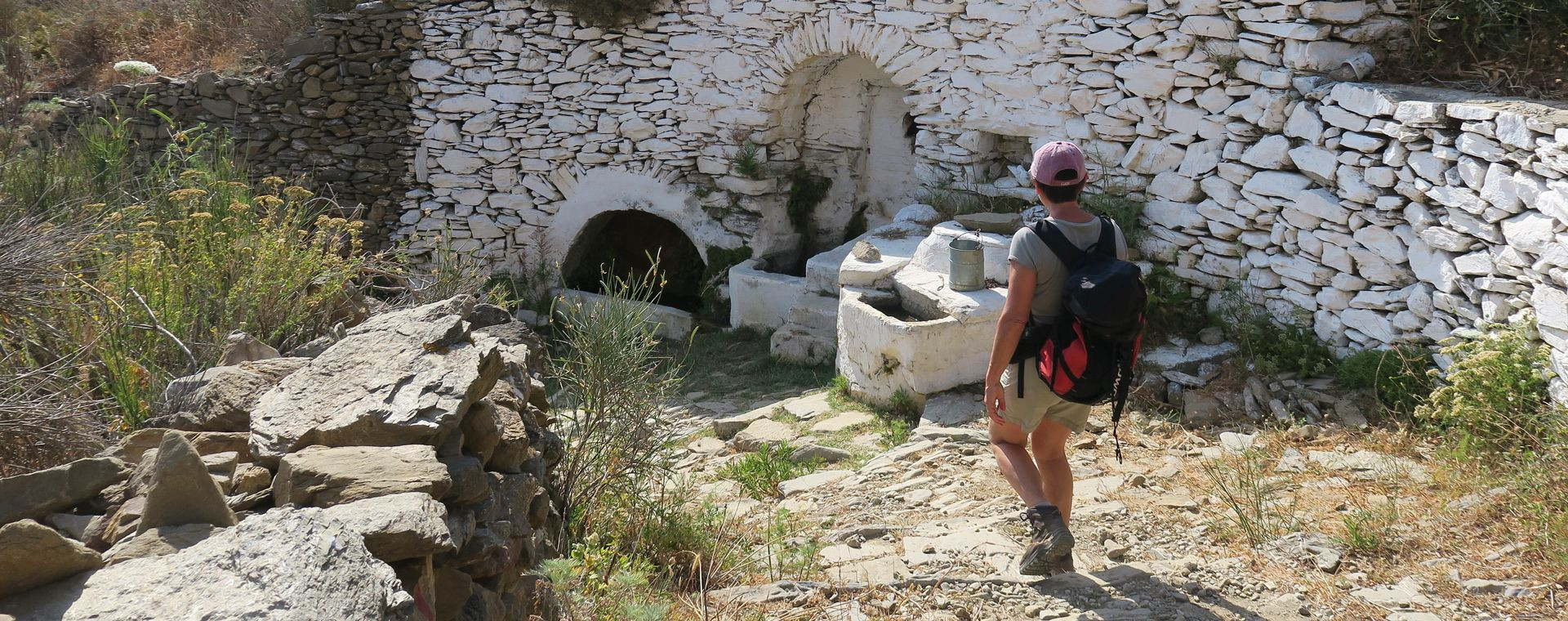 Trekker vicino a una fontana in pietra - Amorgos - Grecia