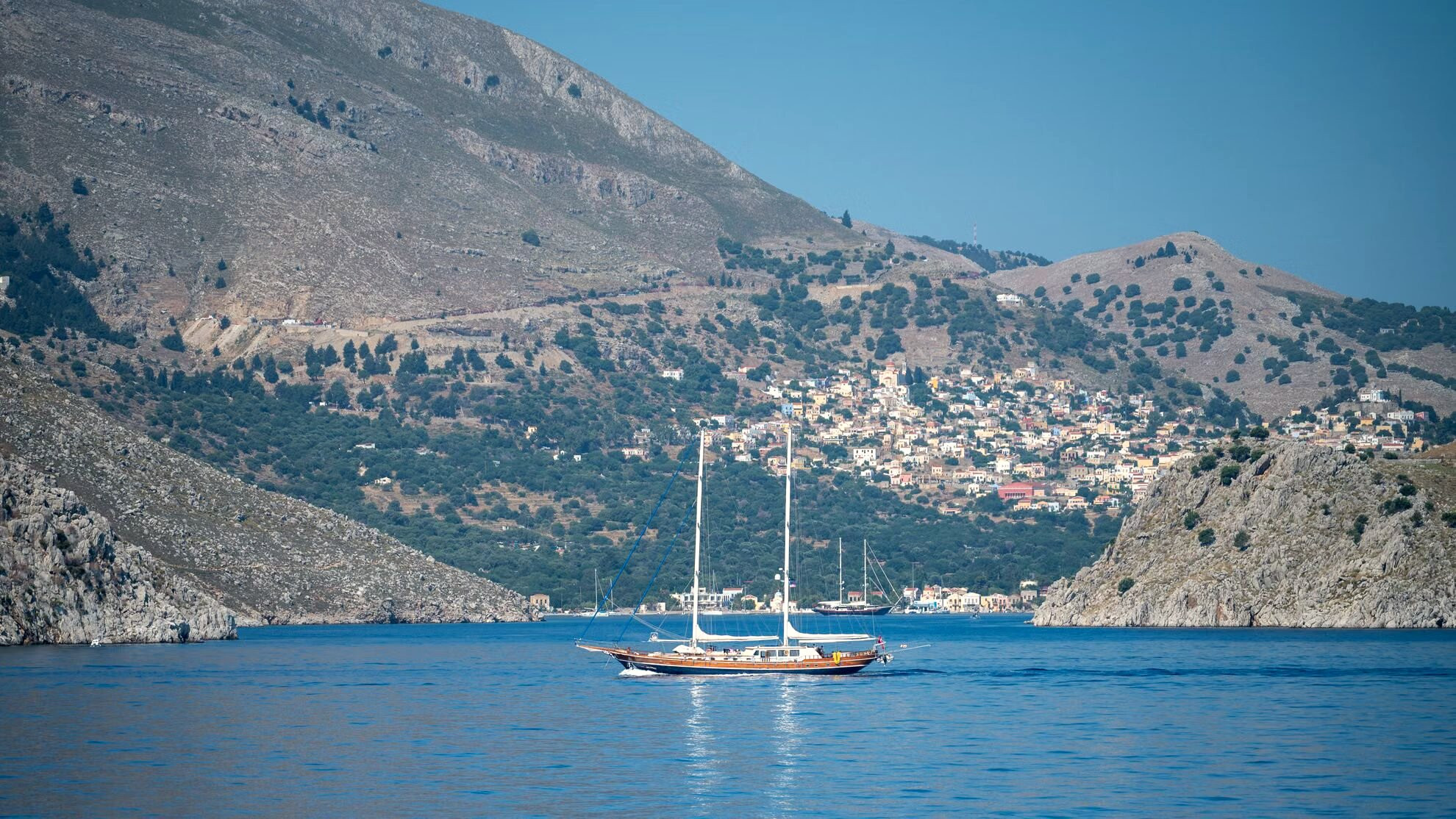 Barca a vela all'ancora in una baia ai piedi delle scogliere - Simi - Grecia